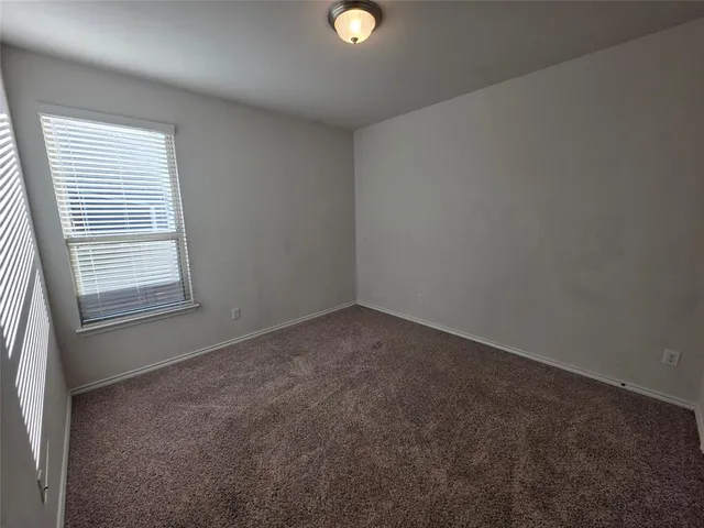 an empty room with windows and with exposed radiator