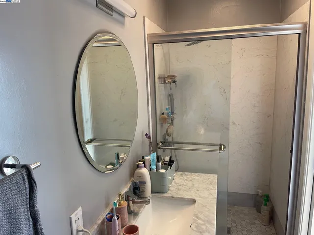 a bathroom with a sink a mirror and a shower