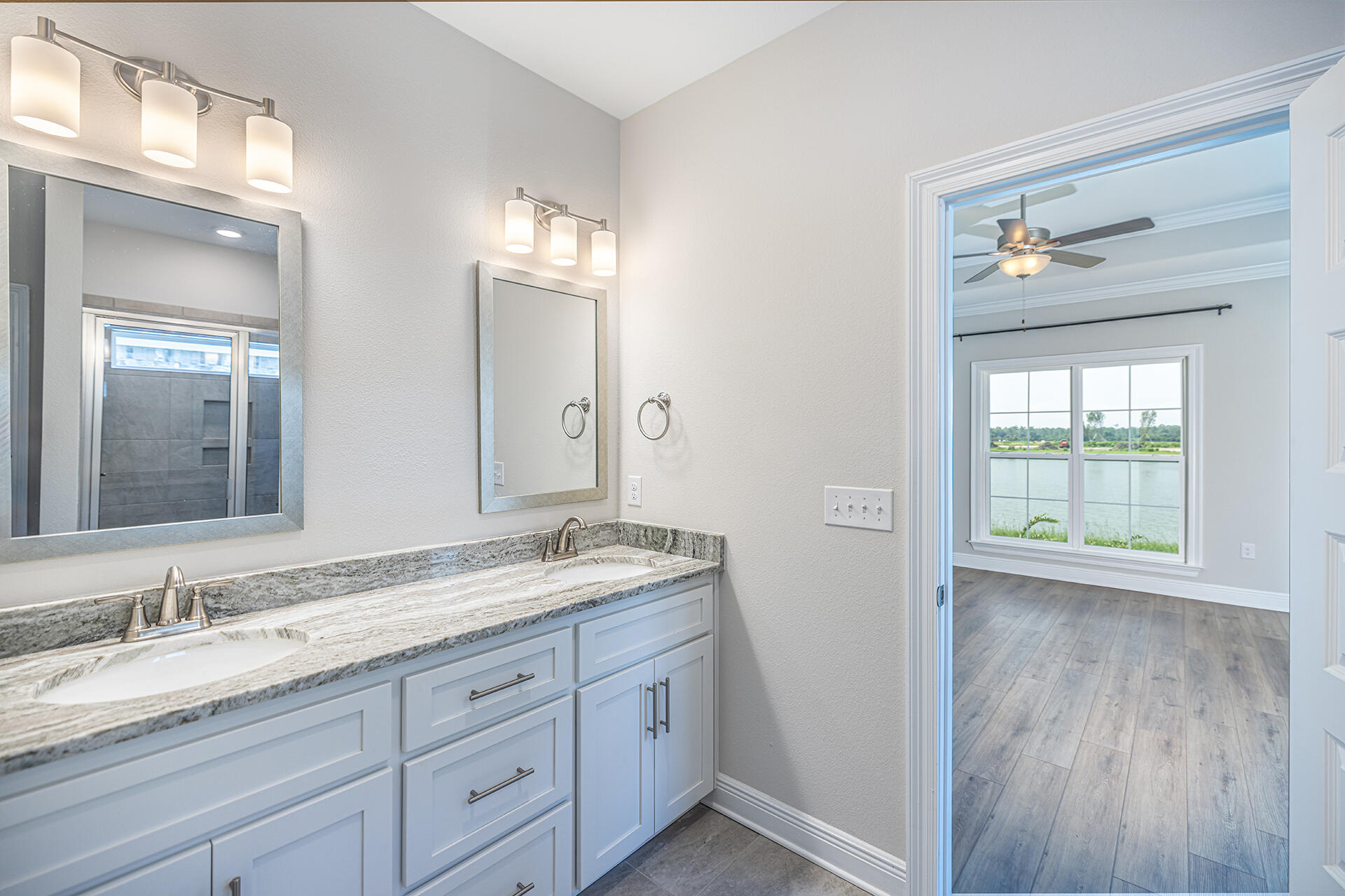 8959 Eureka Street Milton, FL 32583 - Photo 24 of 37 a bathroom with a granite countertop sink mirror and cabinets