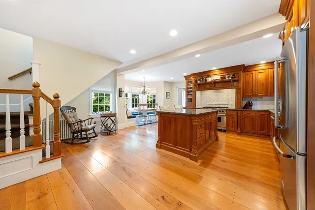 a living room with couches and kitchen view with wooden floor