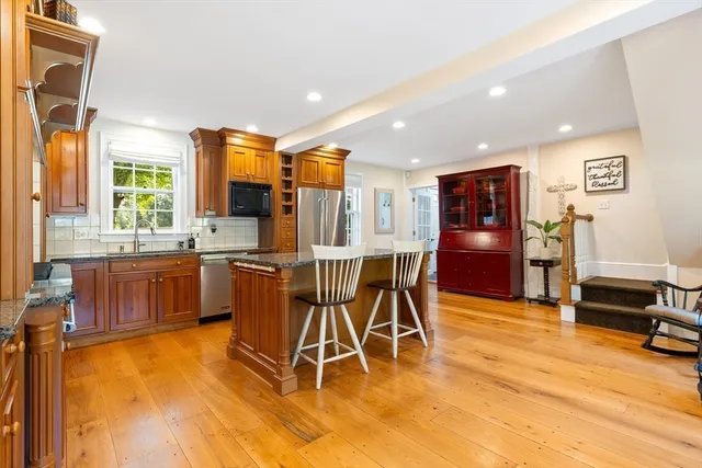 a dining hall with stainless steel appliances a dining table and chairs with wooden floor