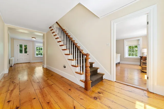 a view of an entryway with wooden floor and a livingroom view