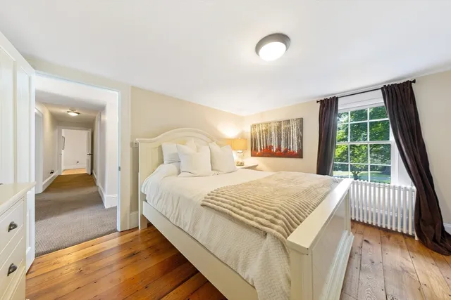 a bedroom with a bed and a large window