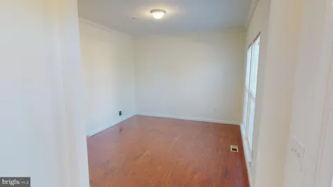 a view of a hallway with wooden floor and stairs