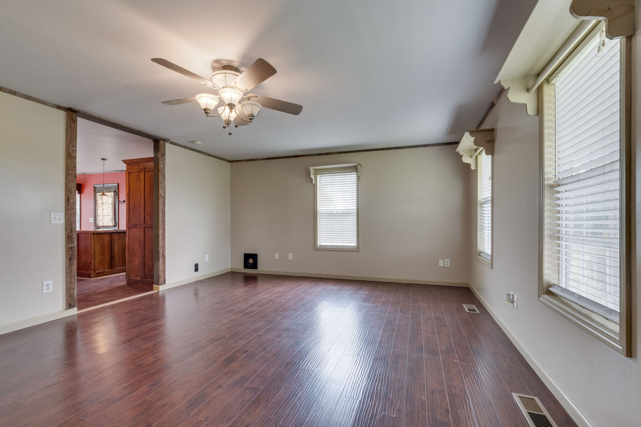 482 Rabbit Trail Road Leoma, TN 38468 - Photo 8 of 33 an empty room with wooden floor chandelier fan and windows
