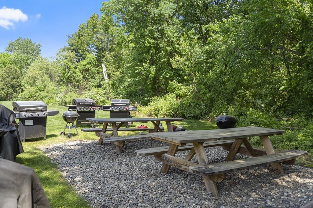 37 Leonard Road, Unit 37 Boxborough, MA 01719 - Photo 17 of 20 a view of a patio with table and chairs under an umbrella