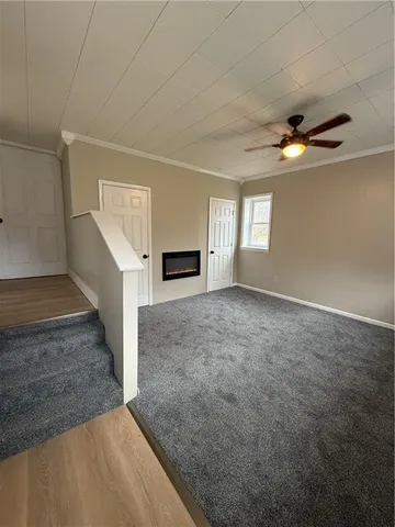 an empty room with windows and fireplace