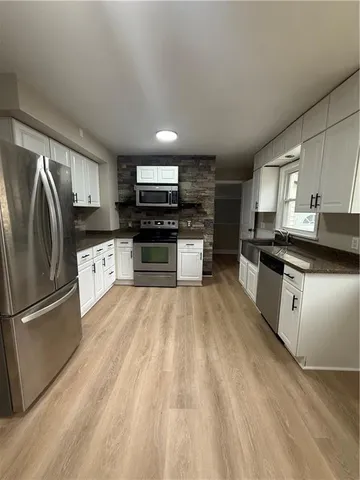 a kitchen with stainless steel appliances granite countertop a refrigerator a stove top oven a sink and dishwasher