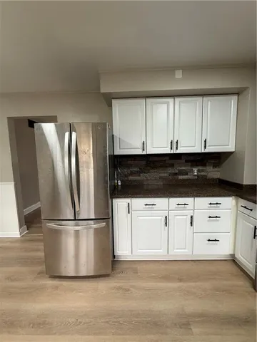 a kitchen with granite countertop white cabinets and stainless steel appliances