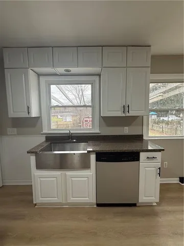 a kitchen with kitchen island granite countertop a stove and a white cabinets