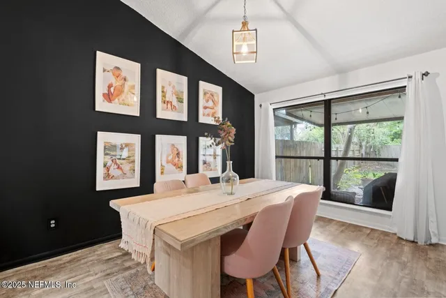 a view of a dining room with furniture large windows and wooden floor