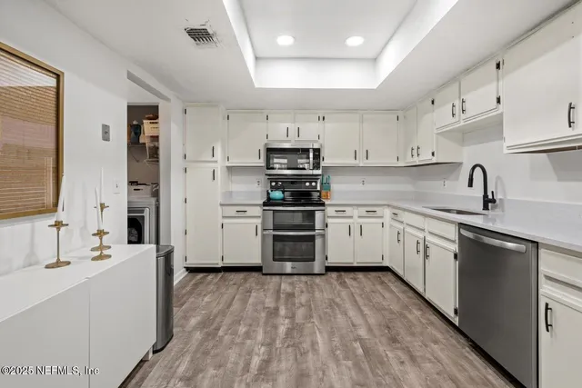a kitchen with cabinets a sink and a stove top oven