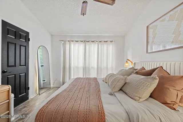 a bedroom with a bed a couch and a window