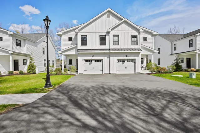 a view of a white house with a yard and plants