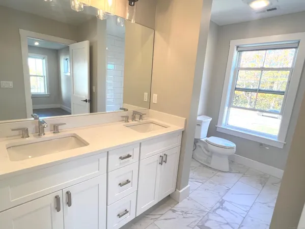 a bathroom with a sink a toilet and a mirror