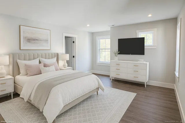 a spacious bedroom with a bed and a flat screen tv