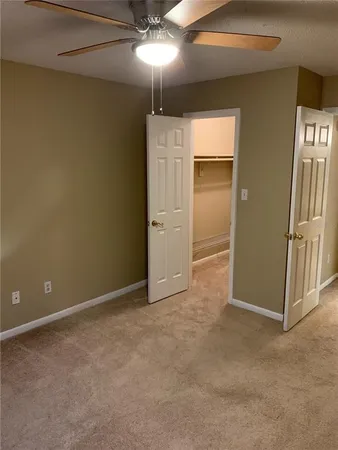 an empty room with chandelier fan