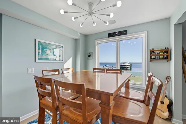 a kitchen with stainless steel appliances granite countertop a table chairs sink and cabinets