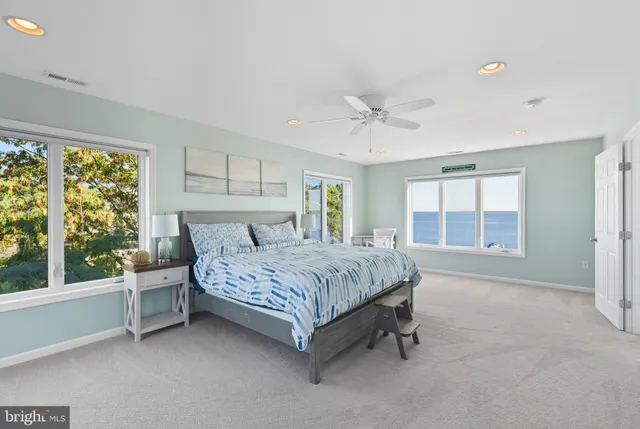 a spacious bedroom with a bed lamp and window