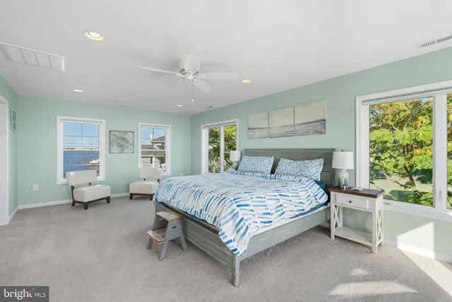 a spacious bedroom with a bed couch and windows