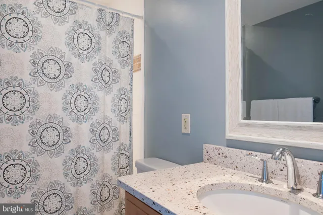 a bathroom with a sink and mirror with bathtub