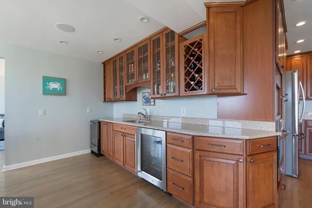 a large kitchen with stainless steel appliances granite countertop a lot of counter space and wooden floor