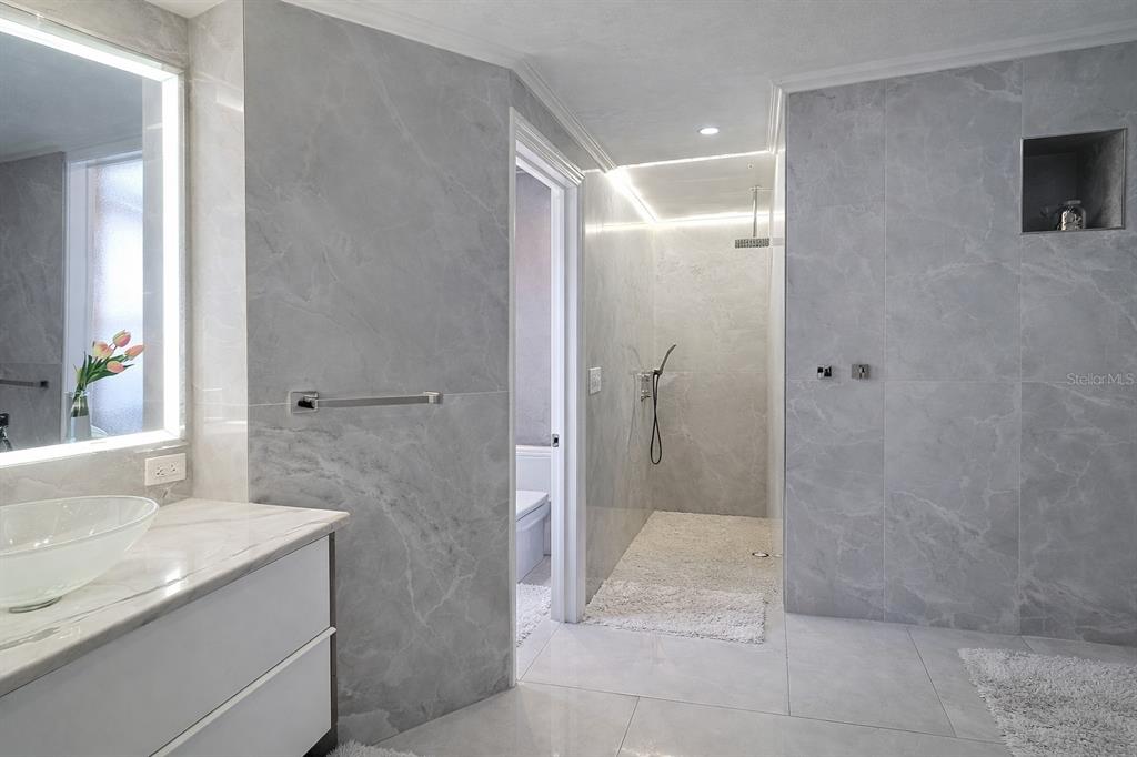 1840 Flametree Lane Venice, FL 34293 - Photo 16 of 26 a bathroom with a granite countertop sink a shower and a mirror