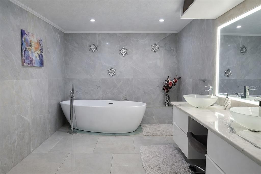 1840 Flametree Lane Venice, FL 34293 - Photo 17 of 26 a bathroom with a tub a sink and mirror