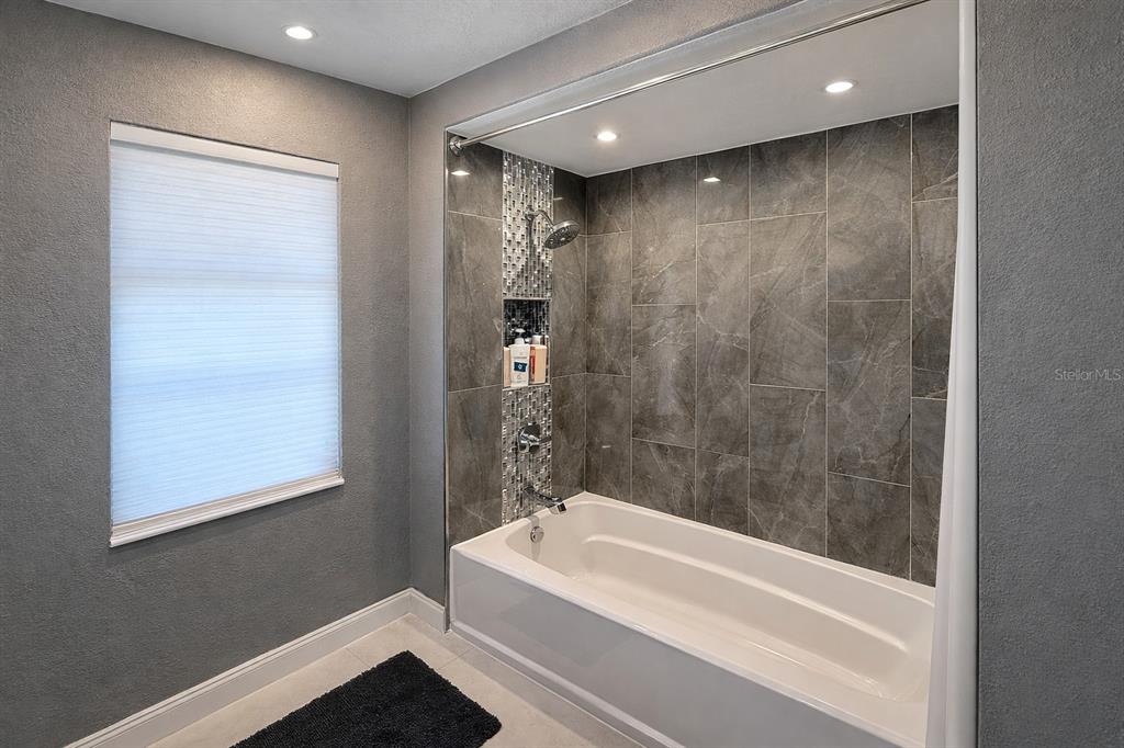 1840 Flametree Lane Venice, FL 34293 - Photo 20 of 26 a bathroom with a bathtub a shower and a sink