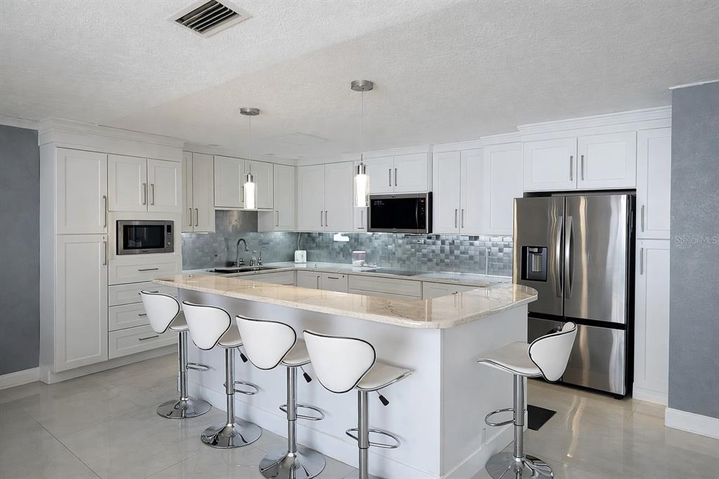 1840 Flametree Lane Venice, FL 34293 - Photo 8 of 26 a large kitchen with kitchen island a appliances and a counter top space