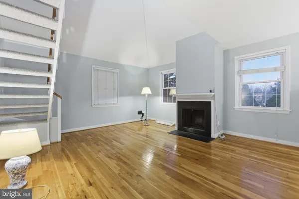 a view of empty room with wooden floor and fireplace