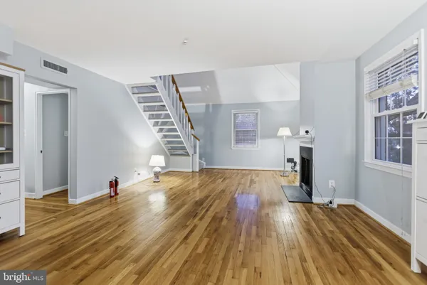 a view of empty room with wooden floor and staircase