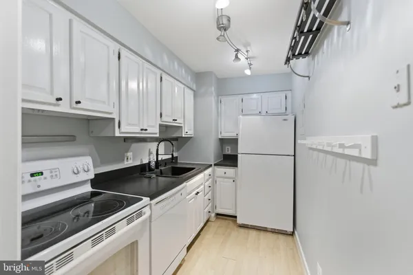 a kitchen with a sink a refrigerator and cabinets