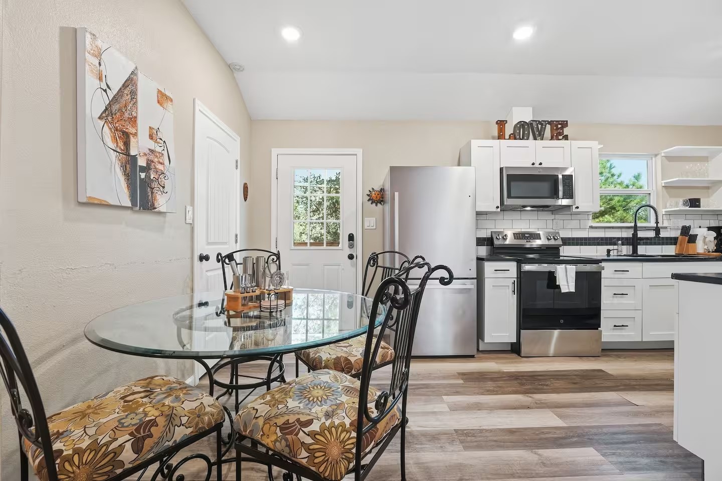 201 Winfield Thicket Road Bastrop, TX 78602 - Photo 16 of 36 a kitchen with stainless steel appliances kitchen island granite countertop a dining table and chairs with wooden floor