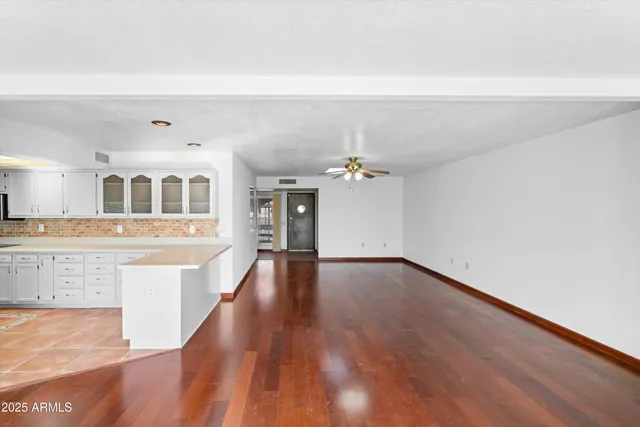 a view of a room with wooden floor and a kitchen