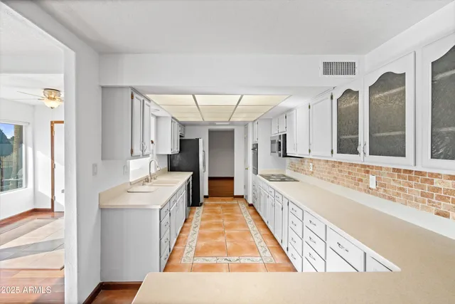 a large white room with a large window and stainless steel appliances