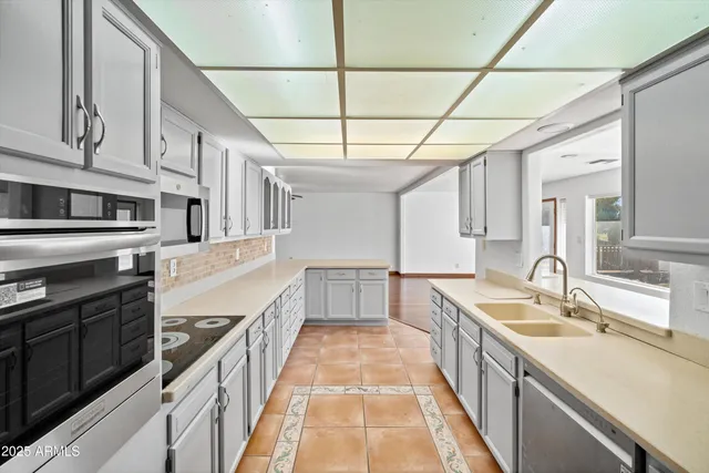 a kitchen with stainless steel appliances granite countertop a sink and wooden cabinets