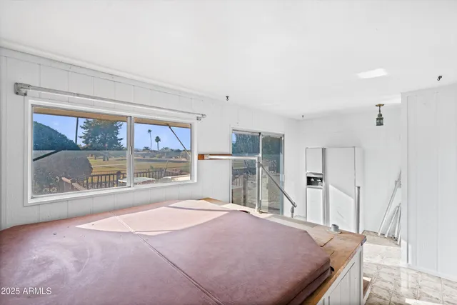 a spacious bedroom with a bed and a large window