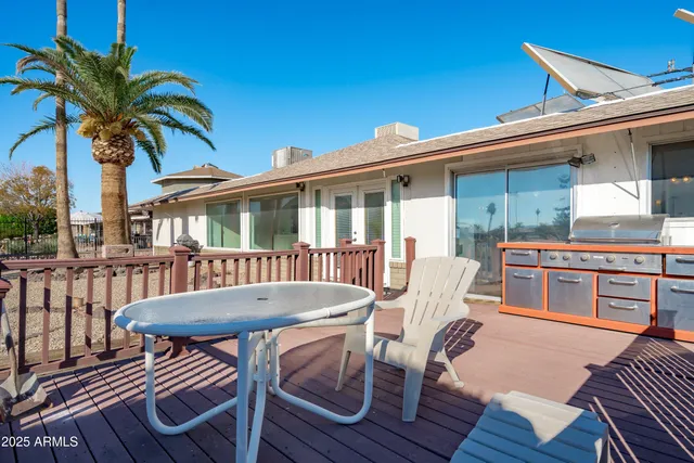 a view of a patio with table and chairs with wooden floor and fence