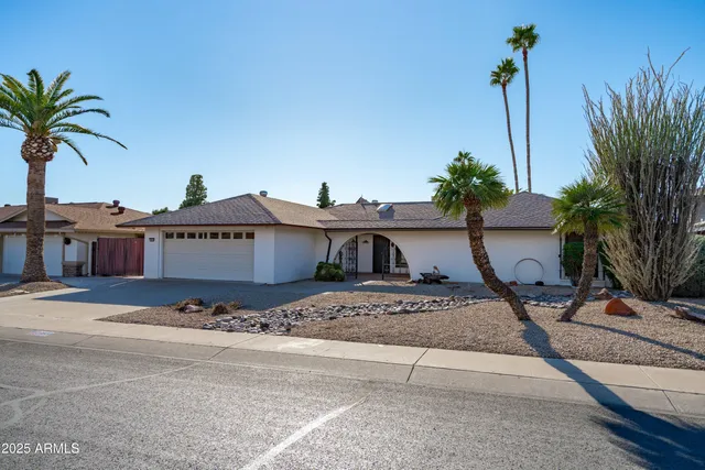 a view of a house with a yard and parking space