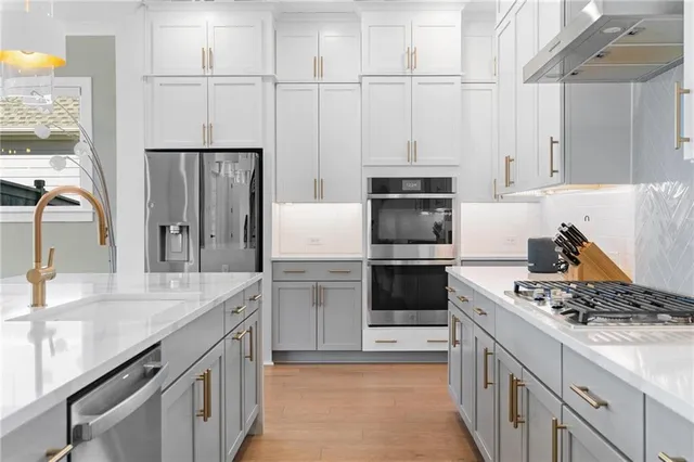 a kitchen with stainless steel appliances granite countertop a stove a sink and a window