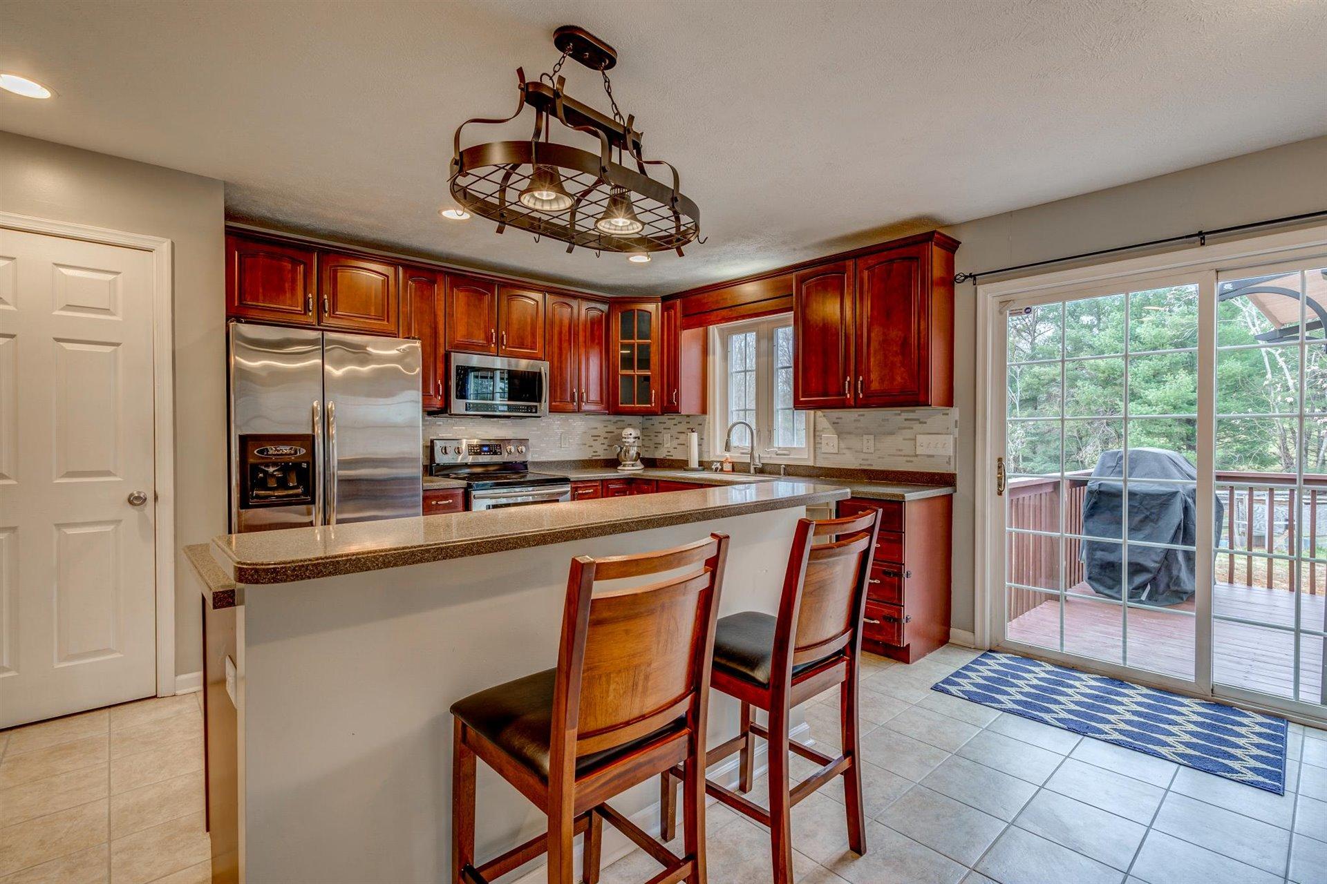 1183 Carroll Road Goodview, VA 24095 - Photo 13 of 61 a kitchen with stainless steel appliances granite countertop a stove a refrigerator a sink dishwasher a dining table and chairs with wooden floor
