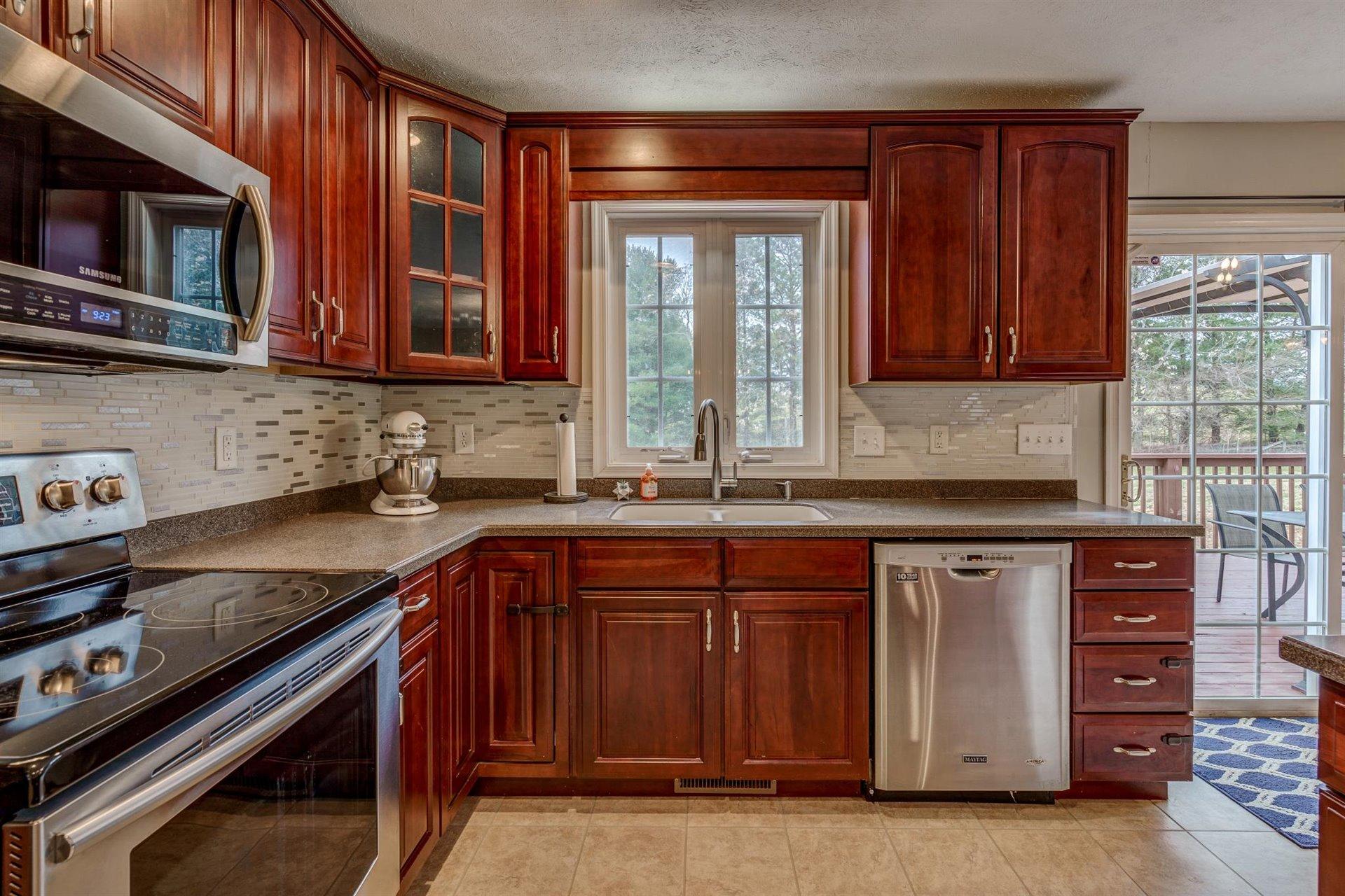 1183 Carroll Road Goodview, VA 24095 - Photo 17 of 61 a kitchen with stainless steel appliances granite countertop a sink stove and microwave