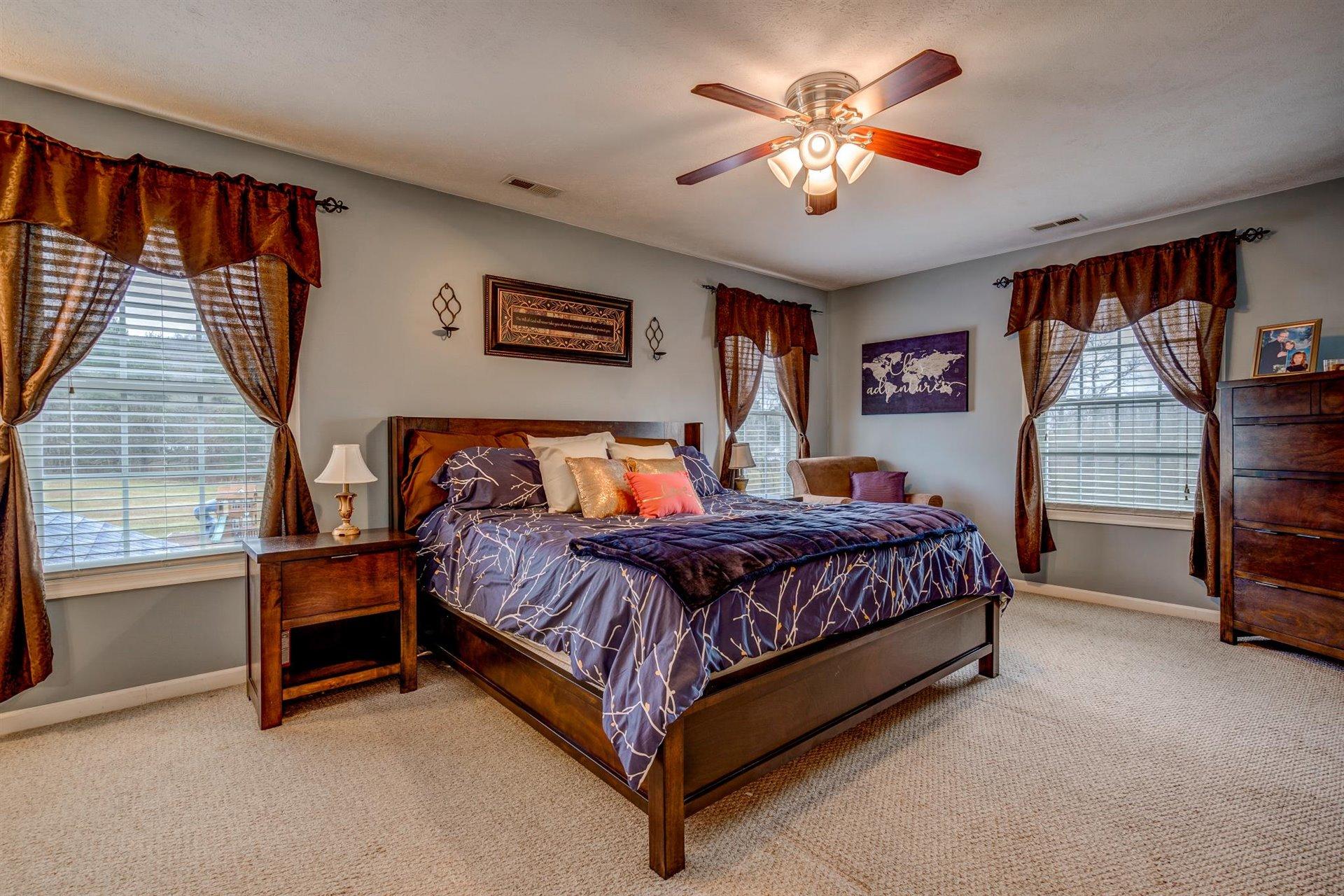 1183 Carroll Road Goodview, VA 24095 - Photo 28 of 61 a spacious bedroom with a bed and a chandelier