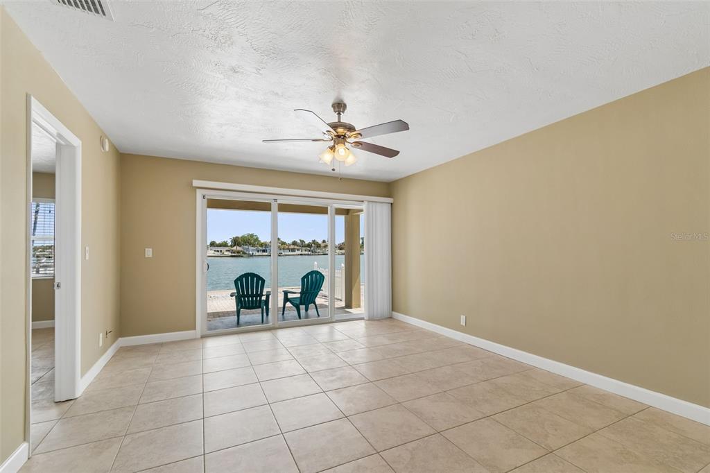 2307 Bay Boulevard Indian Rocks Beach, FL 33785 - Photo 62 of 85 an empty room with windows and chandelier fan
