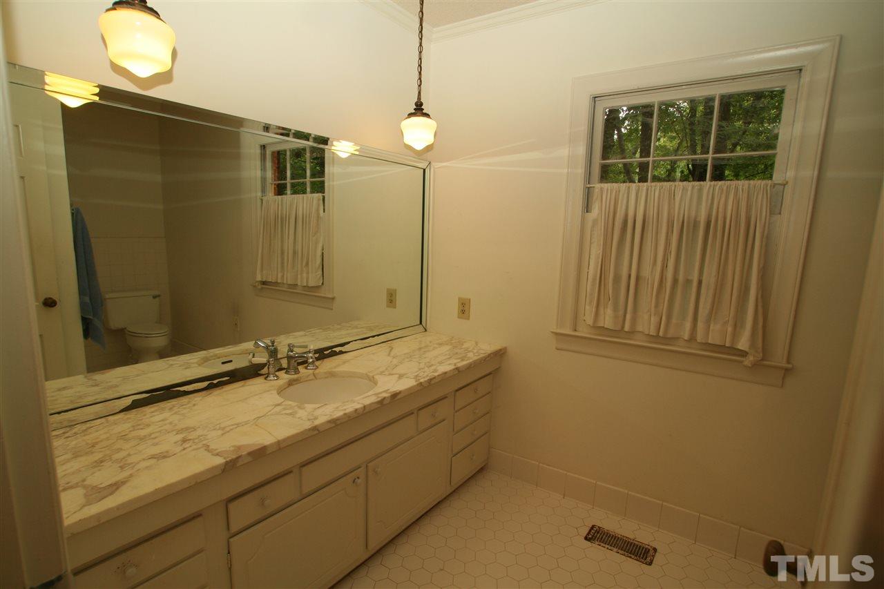 1304 Marlowe Road Raleigh, NC 27609 - Photo 9 of 21 a bathroom with a granite countertop sink a mirror and a shower