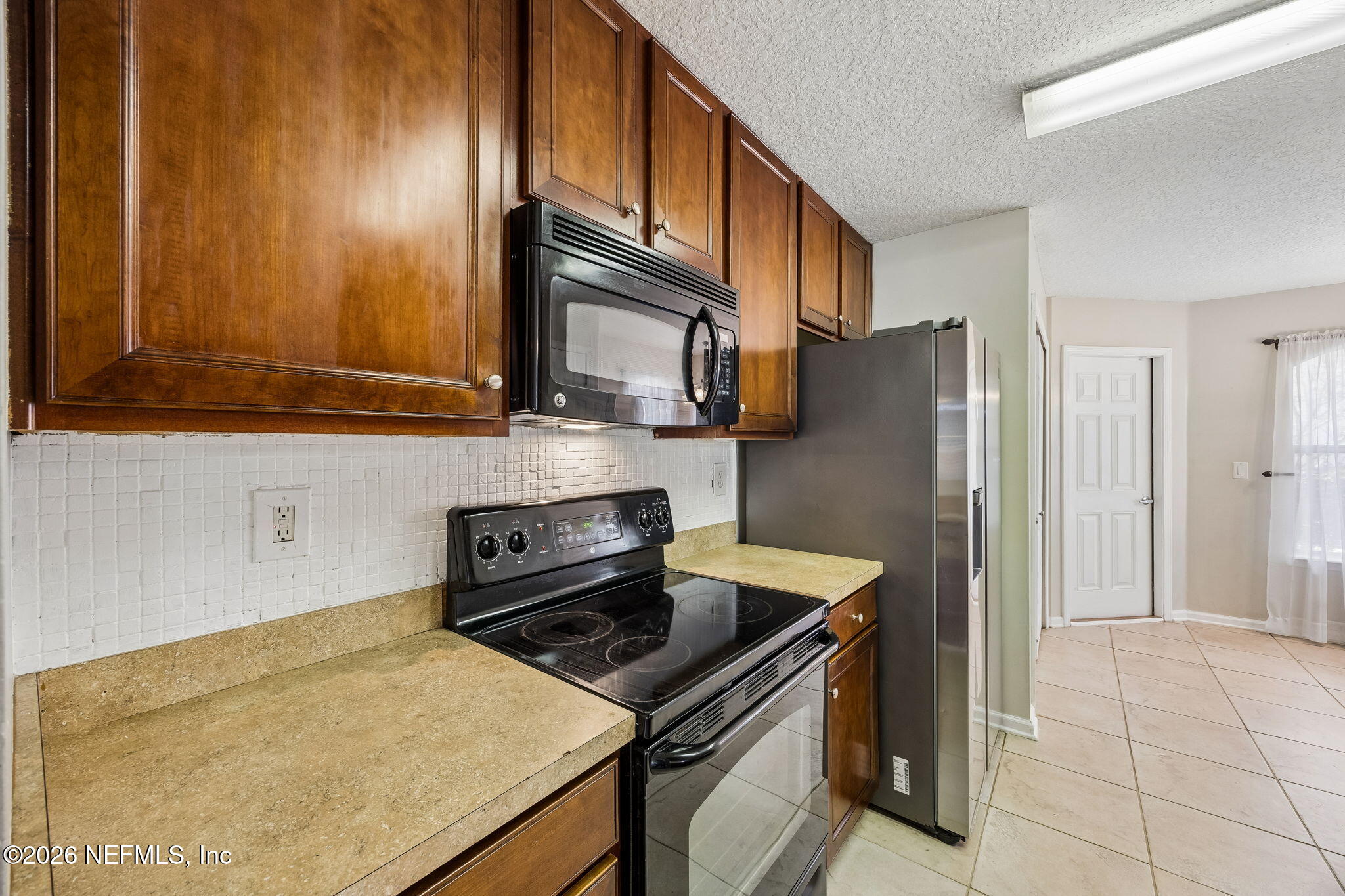 96712 Commodore Point Drive Yulee, FL 32097 - Photo 7 of 24 a kitchen with a refrigerator stove and microwave