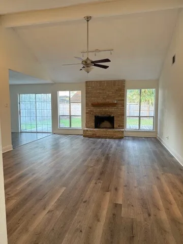 wooden floor fireplace and windows in an empty room