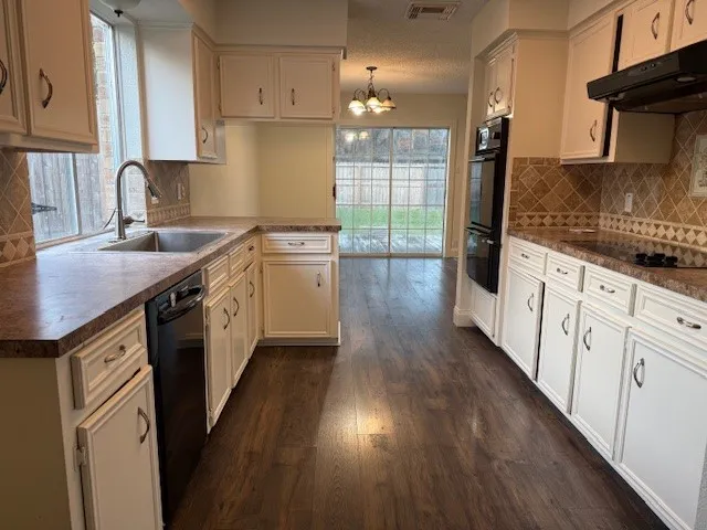 a kitchen with granite countertop a sink stove and cabinets
