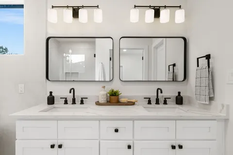 a bathroom with double vanity sinks and a mirror